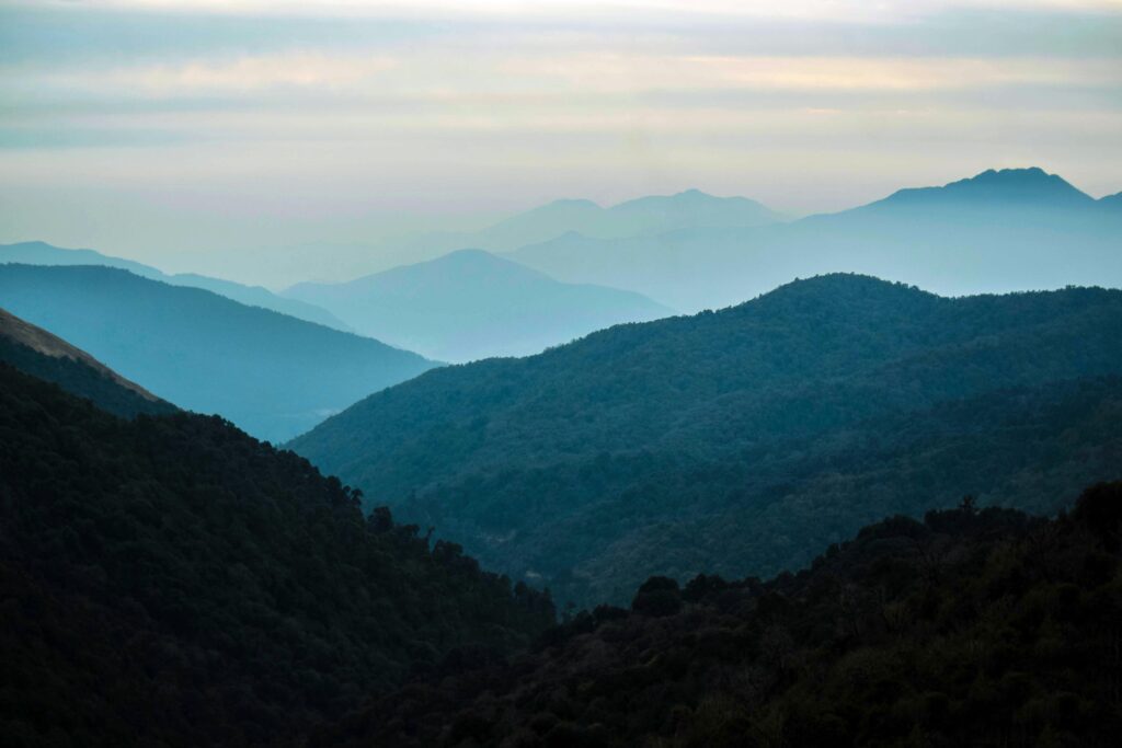 Serene view of misty Himalayan mountains at dusk in Gandaki Province, Nepal.