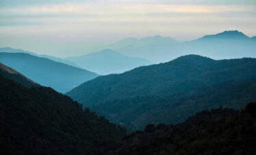 Serene view of misty Himalayan mountains at dusk in Gandaki Province, Nepal.