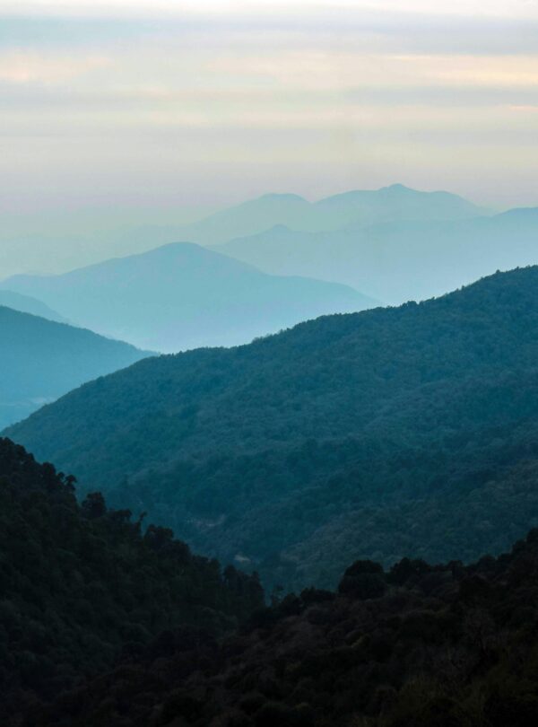 Serene view of misty Himalayan mountains at dusk in Gandaki Province, Nepal.