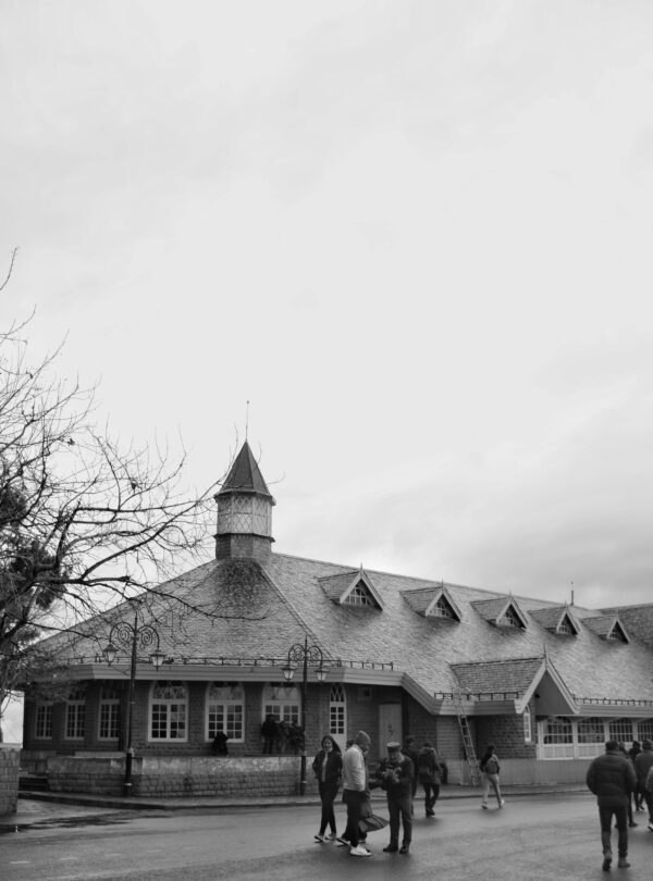 Monochrome photo of a historic building with tourists in Shimla, India, showcasing colonial architecture.